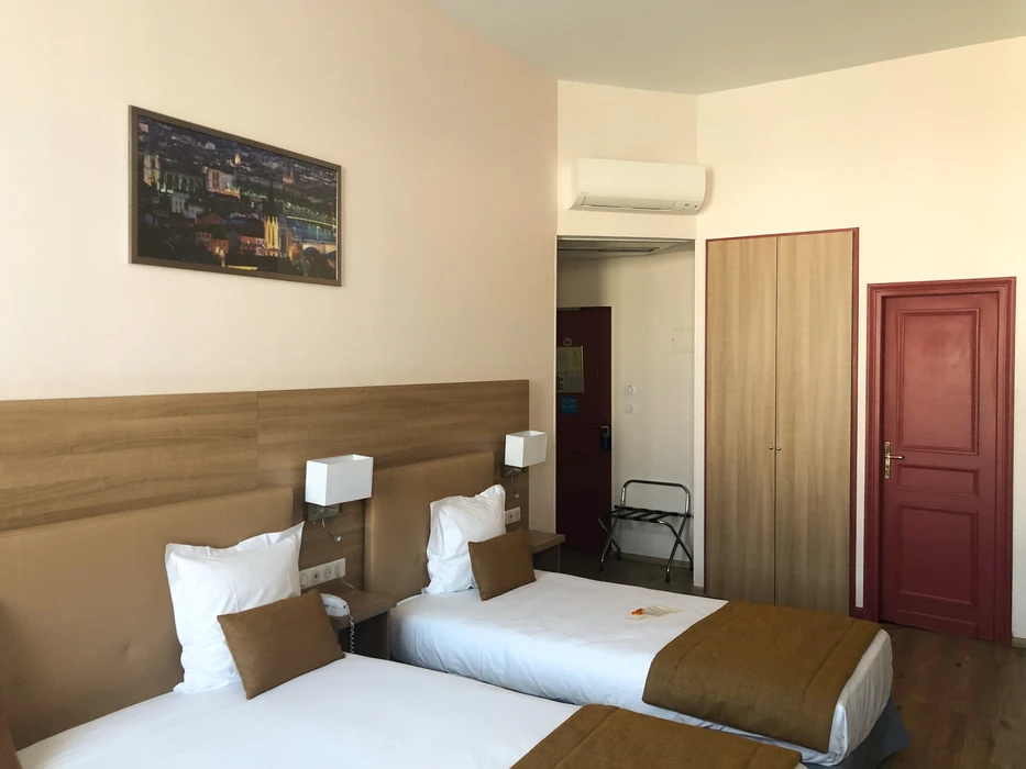Intérieur moderne épuré, mur blanc avec climatiseur mural monté en hauteur, étagère flottante minimaliste supportant un vase décoratif argenté en forme de feuille